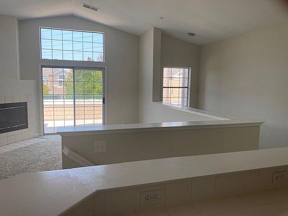 View from the kitchen. Bacony overlooking the trails, the stairs to the garage and a partial view of the fireplace