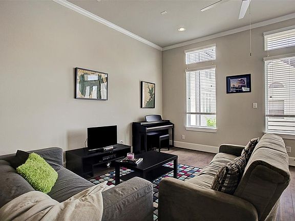 Second floor open-concept living area has high ceilings, recessed lighting, crown moulding, wood floors, and large windows making this space bright and airy.