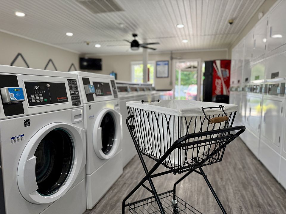Modern laundry room featuring state-of-the-art washing machines and a stylish laundry cart, ideal for convenient and efficient living.