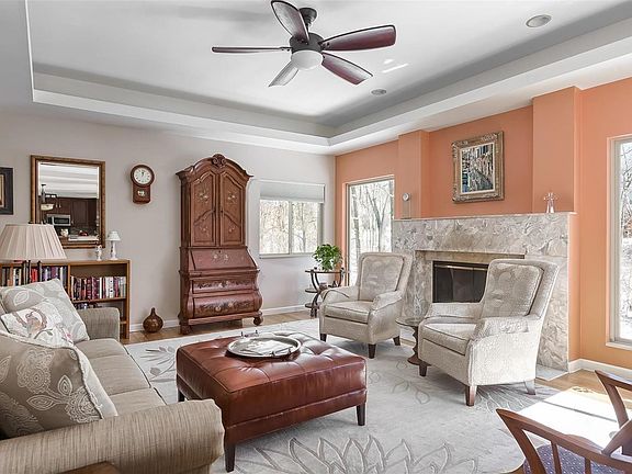 Spacious great room accented with cove lighted ceiling, hardwood flooring, decorative ceiling fan, fireplace and windows providi