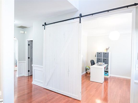Gorgeous Barn door for privacy! Notice the Wainscotting in the Foyer!