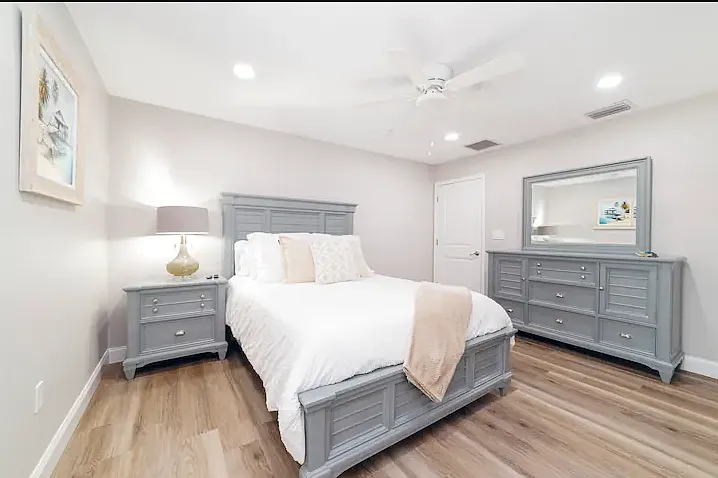 A calming retreat with a queen-sized bed, plush bedding, and modern decor, perfect for restful nights.