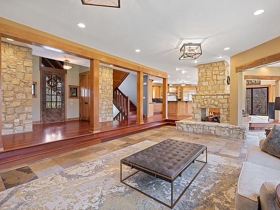 Four-sided fireplace flanks this grand great room as you enter this home.