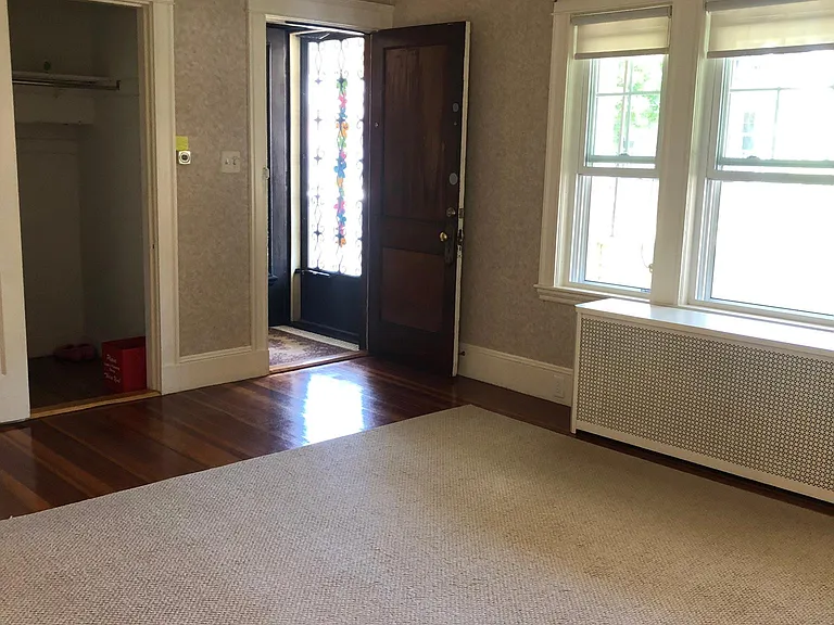 spacious living room with deep coat closet and beam ceilings!