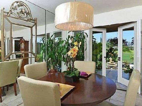 Dining area with open doors to patio on golf course