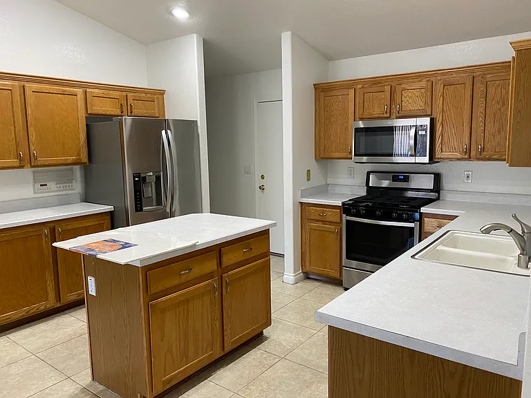 Kitchen - Stainless appliances, island, speaker system to communicate throughout the home or play music. Door to the 3-car garage and home entrance. Washer and dryer down hidden.