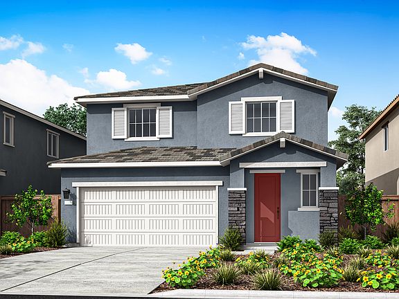 A two-story residential house with a red front door, a white garage door, and a well-landscaped yard