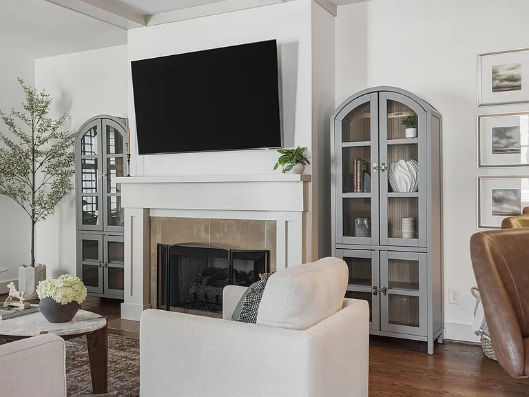 Beautifully designed living room with a fireplace, ceiling fan and plenty of comfy seating. Smart TV, wood floors, and easy flow into the kitchen.