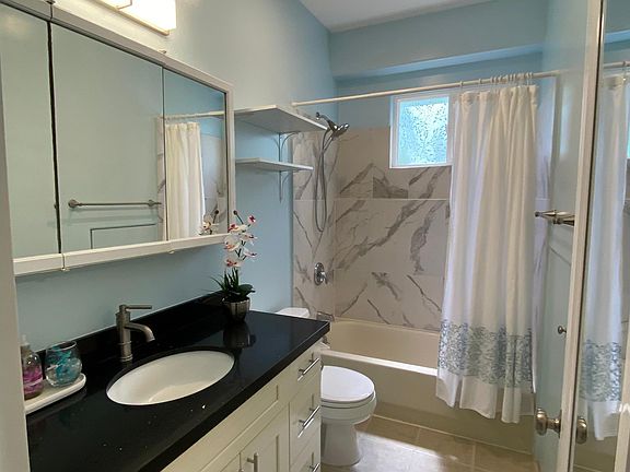 Quartz shower, vanity with quartz countertop and sink, shaker cabinets with soft close drawers and doors.