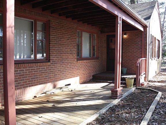 The long front porch, perfect for relaxing - just add patio furniture! The in-ground planter is open for gardening if you'd like.