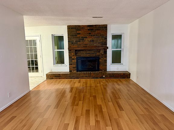 Living Room with fireplace, leading into the kitchen