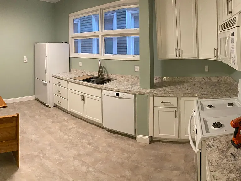 Panoramic of the Kitchen. New Cabinets and Counter tops, Sink, Garbage disposal and Dishwasher. Built In Microwave above the Stove and Fridge