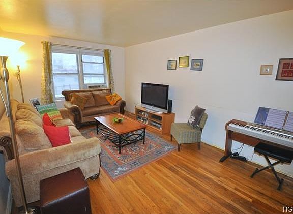Large Bright living room with hardwood floors opens to the large dining foyer.