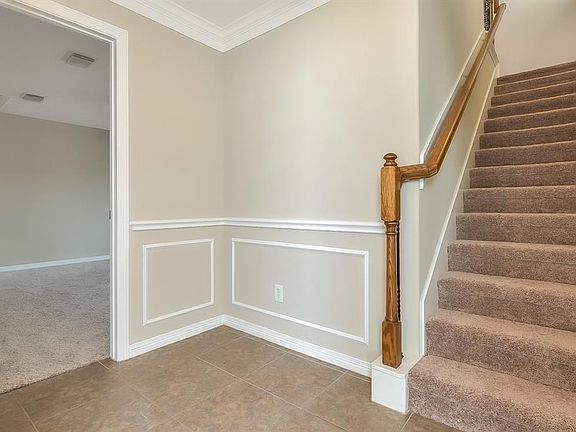 Home has recently been painted and new carpet installed. Stairway leads to second floor where the Kitchen, Dining, and Family Room are. One of three bedrooms is on the left.