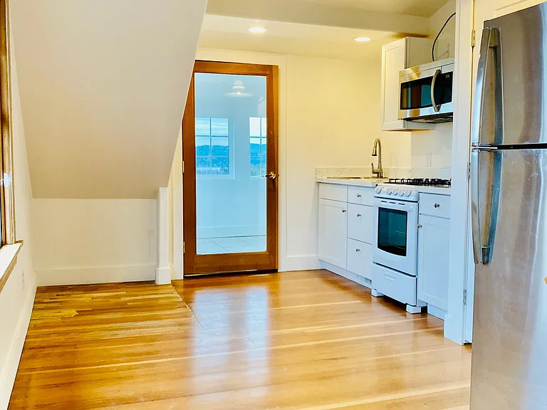 Top of stairs and view of kitchen and living room