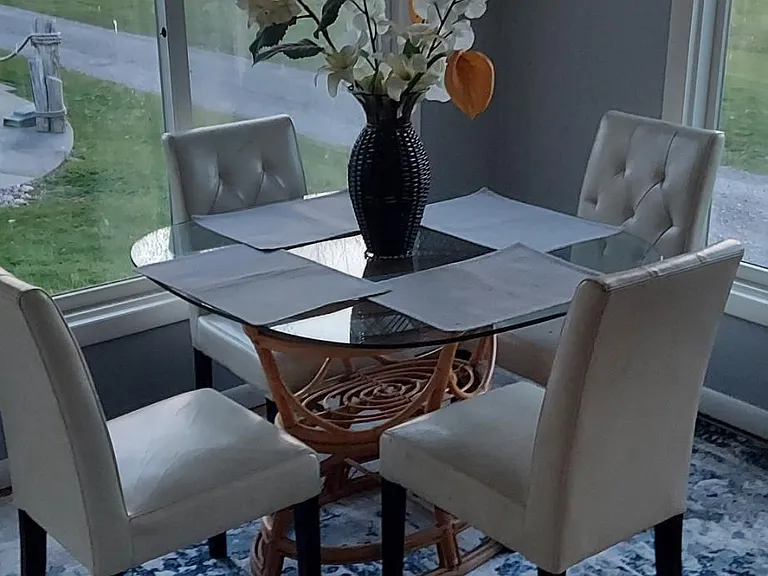 Enclosed porch contains couch and full dining set plus view