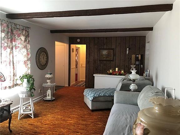 View of Living Room facing the Entry on the left and wood accent wall. Doorway to the left of the Entry leads to the Bedrooms.