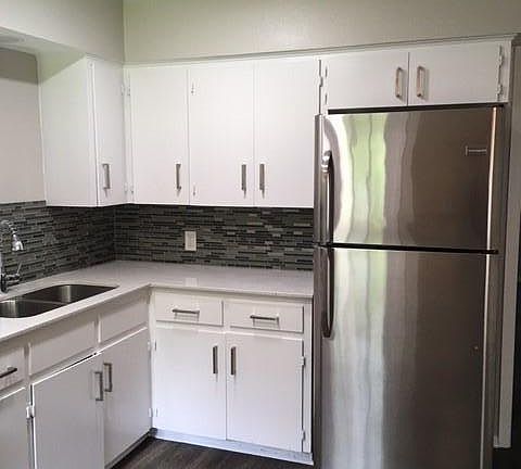 Kitchen is updated with stainless steel appliances, backsplash, recessed lighting and ceiling fan.