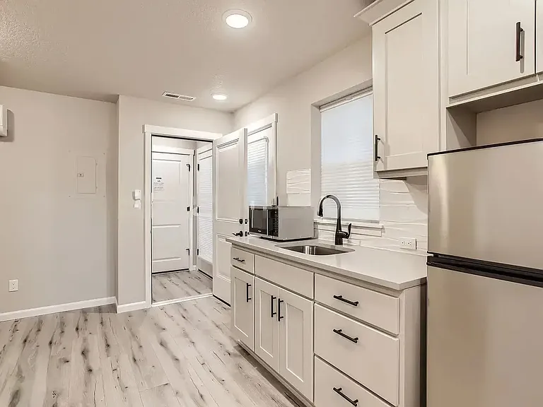 This unit offers a kitchenette featuring a fridge, sink, cabinets, microwave, coffee machine and electric 2 burner cooktop. A/C and heating also included. 

Unit features laminate flooring throughout and in-unit washer/dryer.