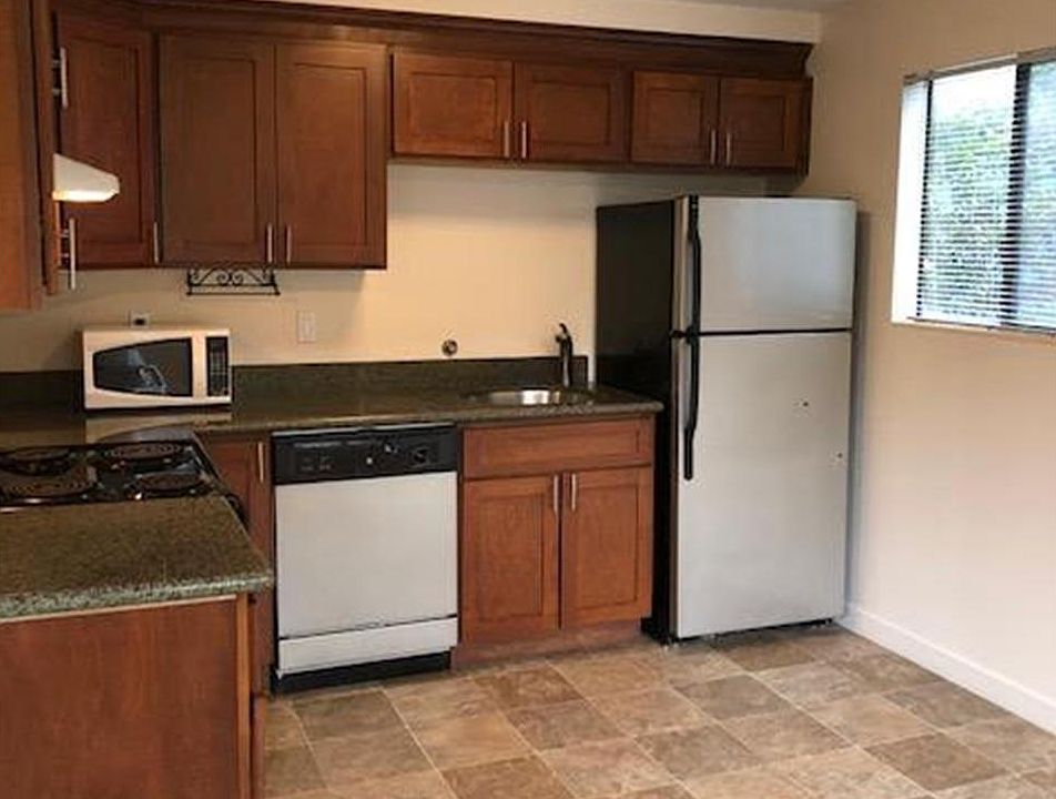 Huge kitchen with stainless steel appliances, granite countertops, cherry cabinets, and enough room for a kitchen table.