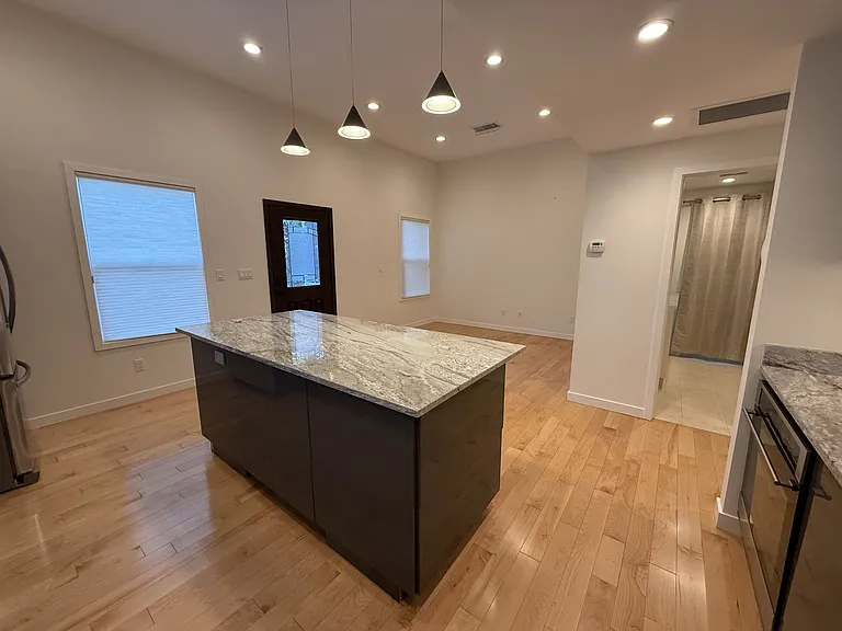 Gourmet kitchen with beautiful granite countertops equipped with stainless steel appliances, featuring a large breakfast island.