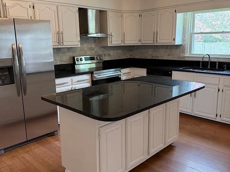 Large island, New fridge, stove, and light fixtures.