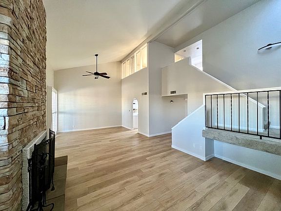 Large great room with new laminate floor, fan, paint and fireplace stone