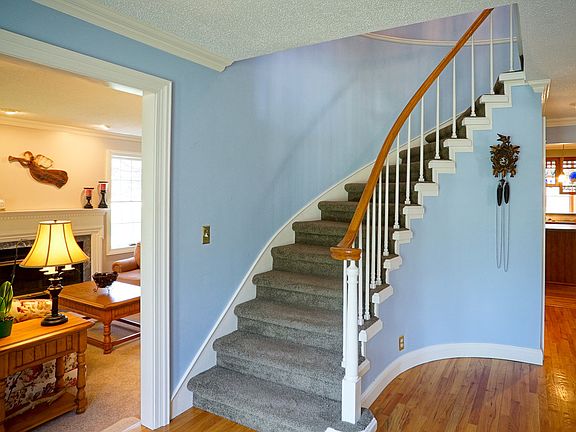 Grand entry with spiral staircase and wood floors.