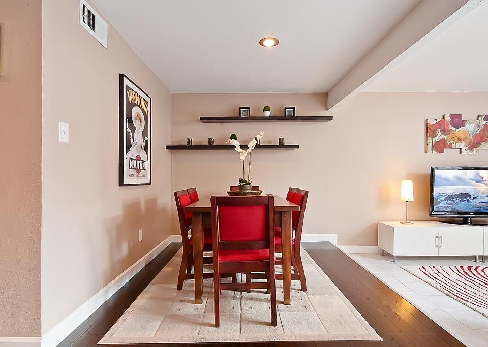 The dining is just off of the kitchen and has bamboo wood flooring, recessed lighting and floating shelves.