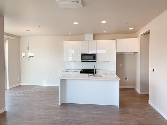 Open floor plan with sunny kitchen.