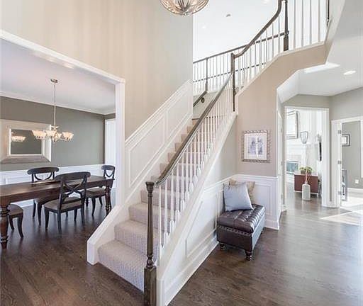 Grand foyer features two story ceiling height with catwalk.  Striking dark hardwood floors with lots of detailed moulding.