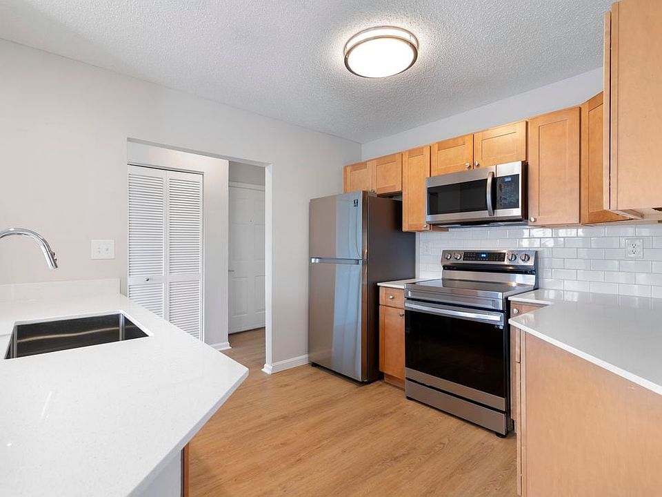 Renovated Package I kitchen with stainless steel appliances, white quartz countertops, maple cabinetry, white tile backsplash, and hard surface flooring