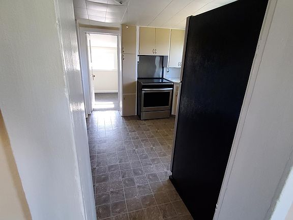 From Livingroom into kitchen. Note the back door to un-heated storage area. it leads to the mudroom.