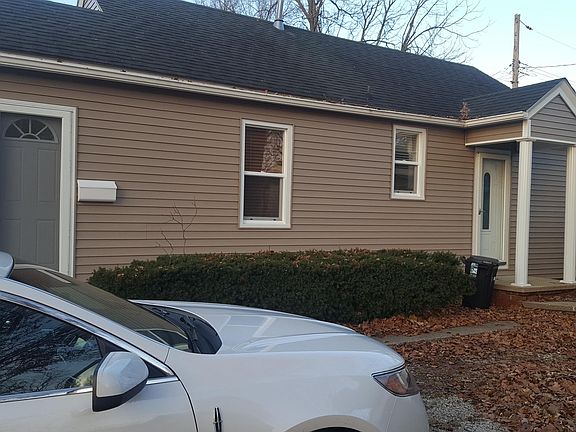 Side view with driveway and looking towards the entry doors. First one with the mailbox is into the foyer. The far one opens into the kitchen.