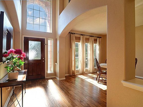 This view captures the true drama and beauty of the space . The expansive arch delineates the Dining Room while large art niches frame the Foyer giving the space flair, volume and architectural interest
