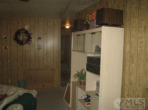 Other side of living room with front door on left and hallway to bedrooms on right.