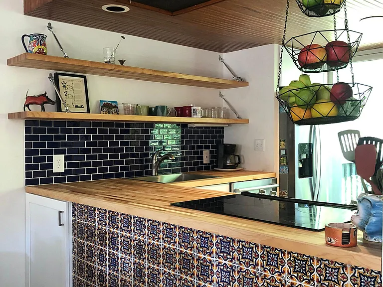 Unique kitchen features hand-painted Talavera tiles. Great for entertaining because slide-in stove faces out to the dining and living areas.