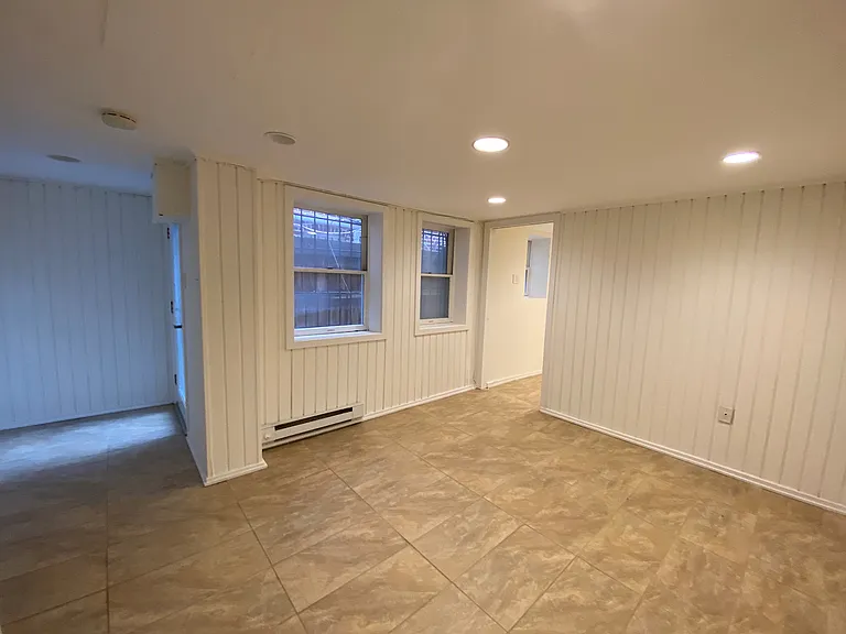Bedroom looking towards back and bonus room. Back entry to apartment on left.