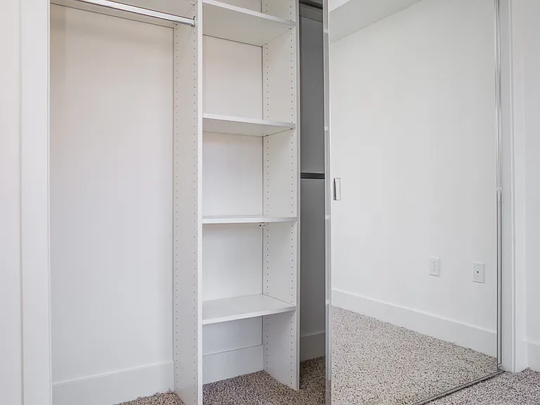 Bedroom with a Mirrored Closet with Built-In Shelves
