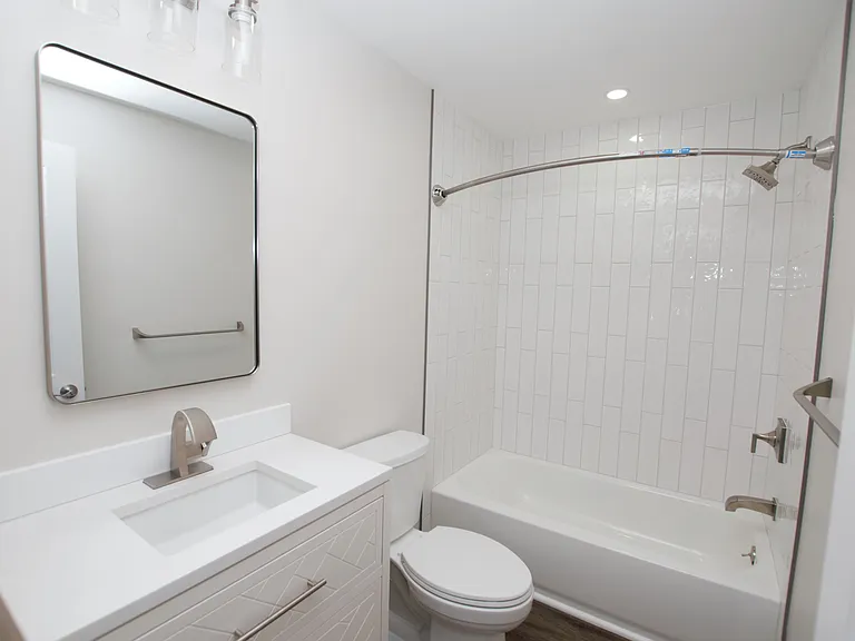 Fully renovated bathroom upstairs with new vanity, toilet, and tiled tub shower