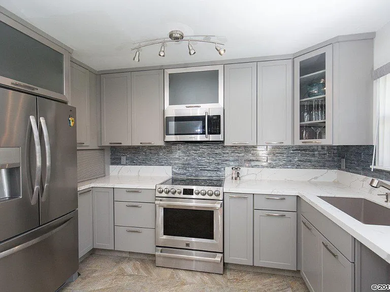 Kitchen with new stainless appliances, including dishwasher