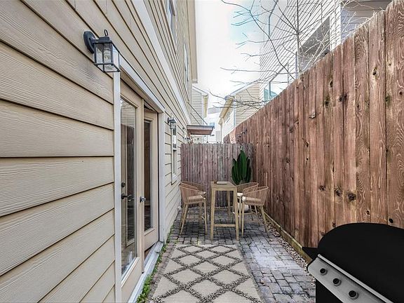Double doors leads to the balcony with room for outdoor cooking and dining as shown by the virtual staging. This private patio has brick pavers and a surrounding fence providing privacy.