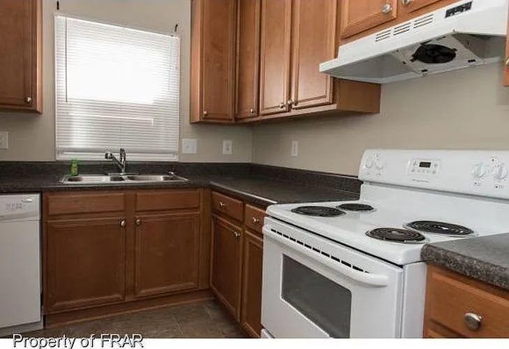 The kitchen has fresh paint, new blinds, many cabinets, and a new refrigerator.