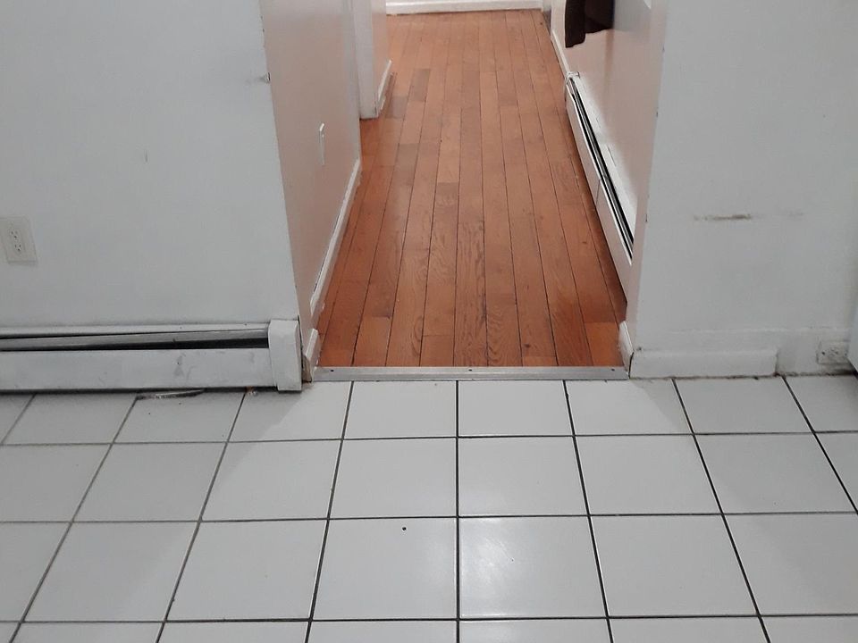 Hallway from the kitchen leading to each of the three bedrooms and back stair and the second bathroom in between.