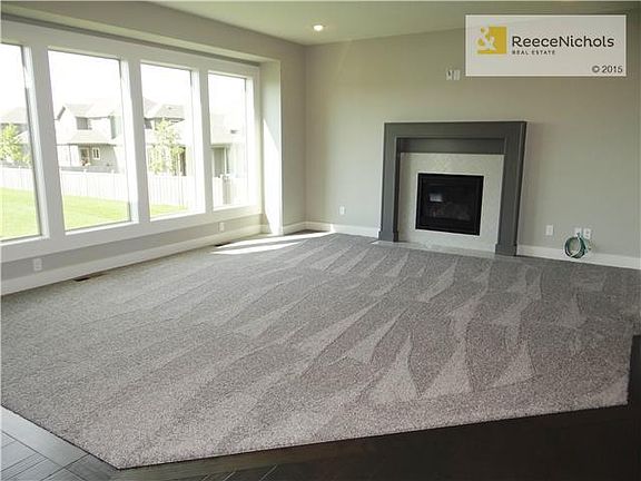 Great room lined with windows and has gas fireplace.