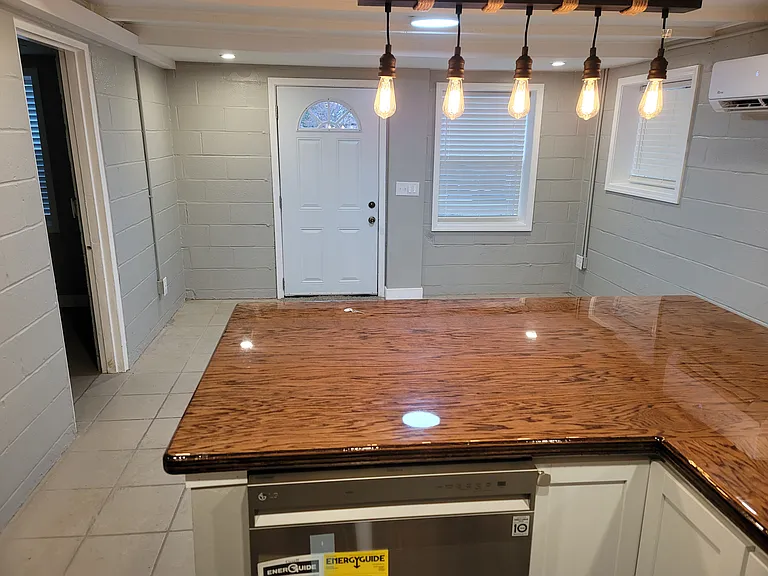 Kitchen, facing the living room. Dimmable bar lights over eat in epoxy countertop.