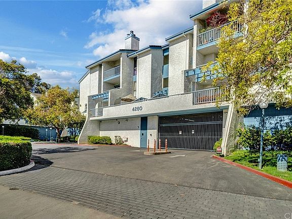 Condo building with secure gated parking and well-maintained landscaping for a welcoming entrance.