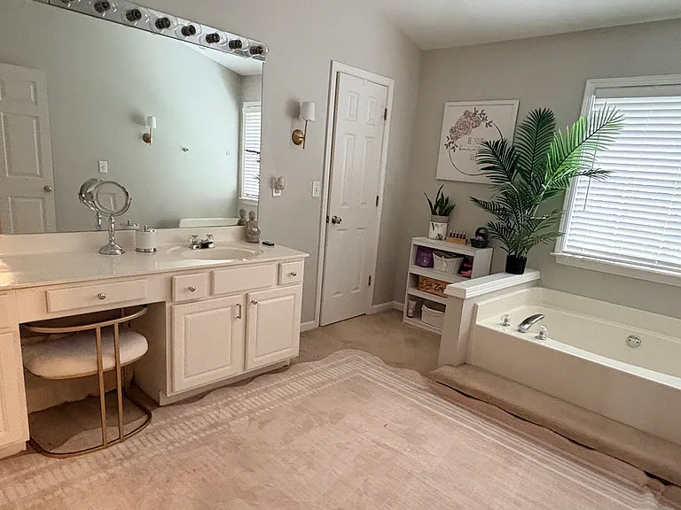 Elegant and spacious primary bath with abundant counter space, oversized mirrors, soaking tub, and walk-in shower for a comfortable and functional retreat experience.