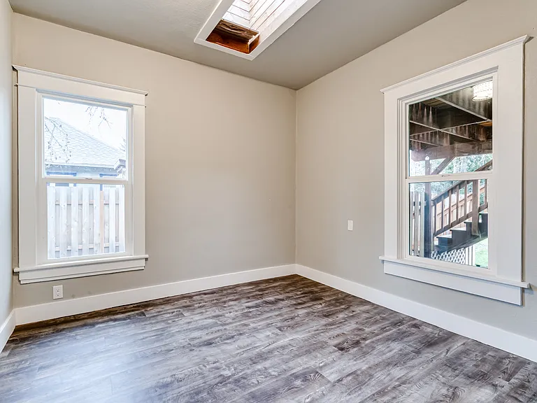Bedroom 1 enjoys a skylight and views toward the backyard.