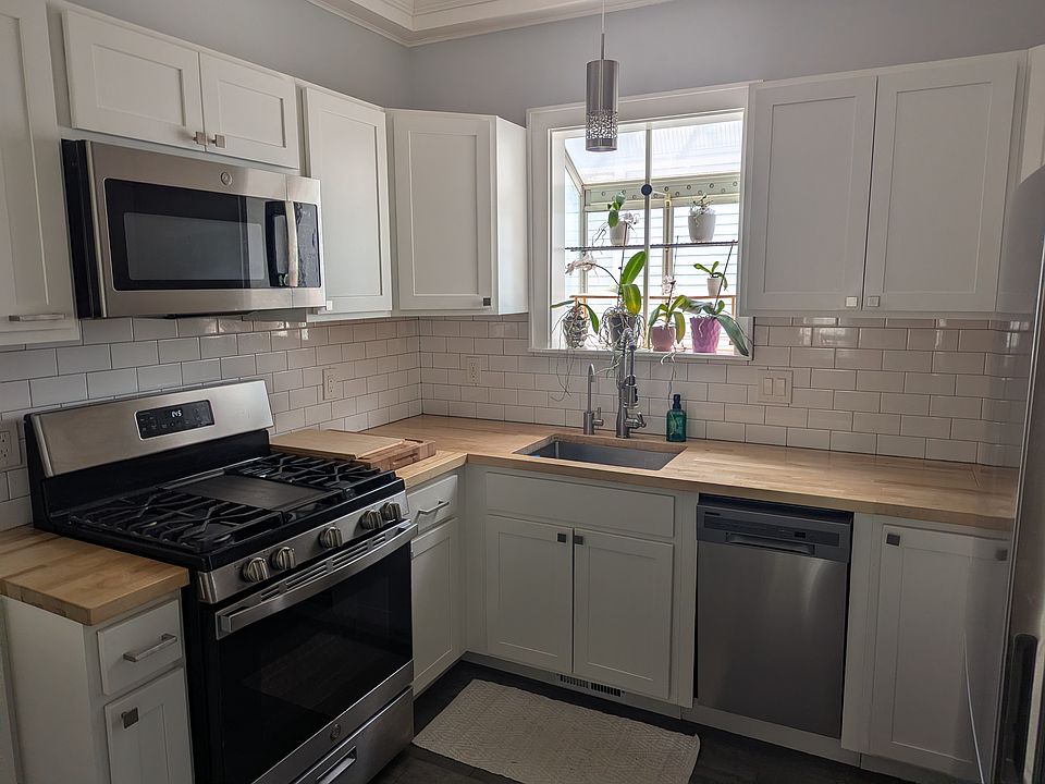 Kitchen with stainless steel appliances, 18" dishwasher, hot (200 degree) water on demand for coffee or tea, slate tile floor, and wooden countertops